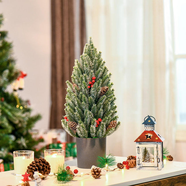 Snow-covered table Christmas tree with berries and pine cones