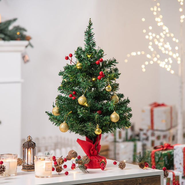 Small green Christmas tree with LED lights and berries